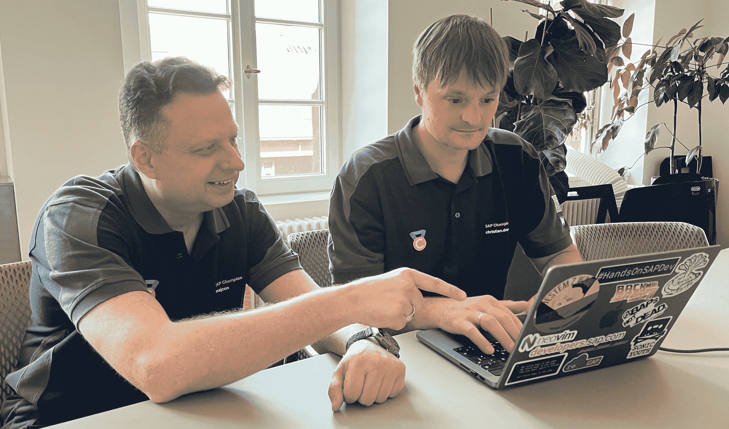 Damir Majer erklärt am Laptop eines Entwicklers ein Stück Code.